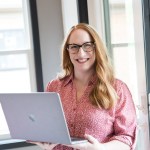 Hadie Mulbey wearing a pink shirt and holding a laptop